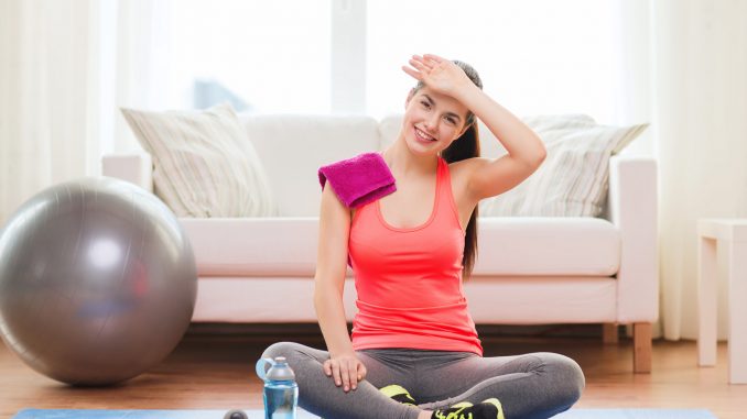 smiling girl with bottle of water after exercising
